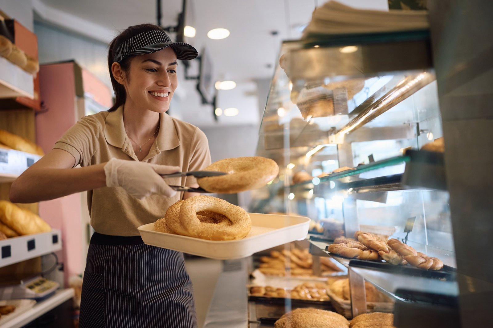 A bakery worker handing over a tray of fresh bread